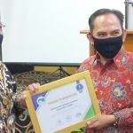 Drs. Chomaidi, Direktur BUMD Depdapgri saat menyerahkan penghargaan kepada Direktur PDAM Jember Ir Ady Setiawan, S.H., M.H., M.M.