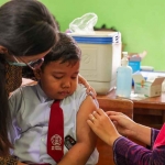 Petugas saat memberikan imunisasi lengkap kepada salah seorang anak dengan acara disuntikkan. Foto: Ist