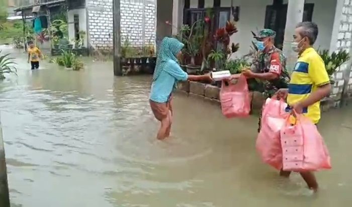 Susuri Banjir di Benjeng Gresik, Serda Untung Bagikan Nasi Kotak kepada Warga Binaannya