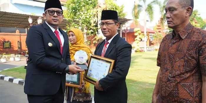 Plt Dinas Pendidikan Kota Mojokerto Rubi Hartoyo (tengah) saat menerima penghargaan dari Pj Wali Kota Mojokerto (dok. Ist)