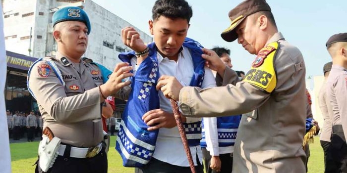 Kapolres Mojokerto Kota, AKBP Wiwit Adisatria saat memberikan secara simbolis rompi Polisi RW kepada salah satu personelnya, Senin (15/5/2023).