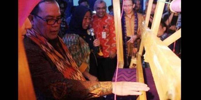 Deputi Gubernur Bank Indonesia, Hendar, tengah mencoba menenun kain menggunakan Alat Tenun Bukan Mesin (ATBM). (Arif Kurniawan/BANGSAONLINE)