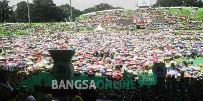 Puluhan Ribu Muslimat NU tak goyah meski panas matahari menyengat. Mereka berteduh di balik payung masing-masing di Stadion Gajayana, Malang, Jawa Timur. foto: BANGSAONLINE