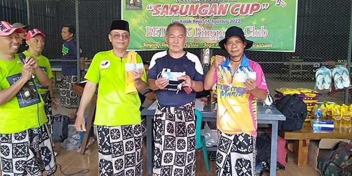 Sinyo Supit (kaos biru) saat menunjukkan uang bonus dari panitia Turnamen Tenis Meja Antarklub di Kediri. Foto: Ist