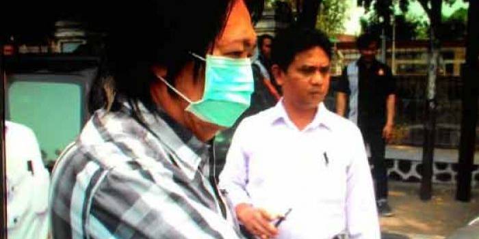 Sony Sandra memakai masker saat digelandang untuk dibawa ke Mapolres Kediri Kota. foto: arif kurniawan/ BANGSAONLINE