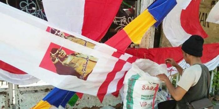 Penjual bendera dan pernak-pernik HUT RI tengah menata barang dagangannya.