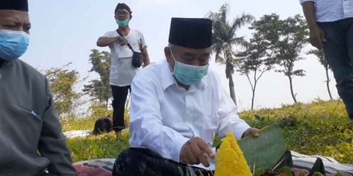 Kiai Asep memotong tumpeng tanda diresmikannya lahan yang disiapkan untuk percontohan pertanian, peternakan, dan perikanan.