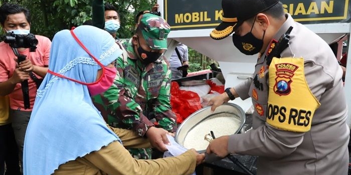 Kapolres Mojokerto sedang memberikan bantuan beras kepada salah satu warga.