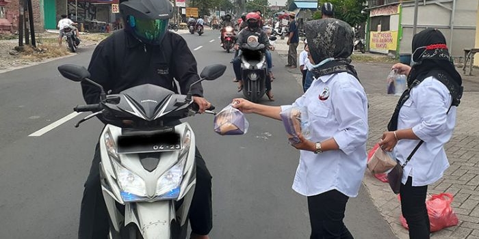 Pengendara sepeda motor menerima takjil dari Relawan Gus Barra.