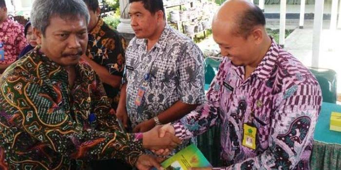 Kadishub Sidoarjo, Joko Santosa (kiri) saat memberikan buku UU perkeretaapian kepada Camat Gedangan Abdul Muid di pendopo Kecamatan Gedangan. foto: nanang ichwan/ BANGSAONLINE