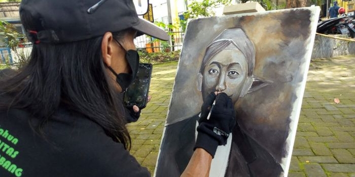 Sugeng Hartobi saat melukis wajah Raden Djokomono alias Tirto Adhi Soerjo. foto: AAN AMRULLOH/ BANGSAONLINE