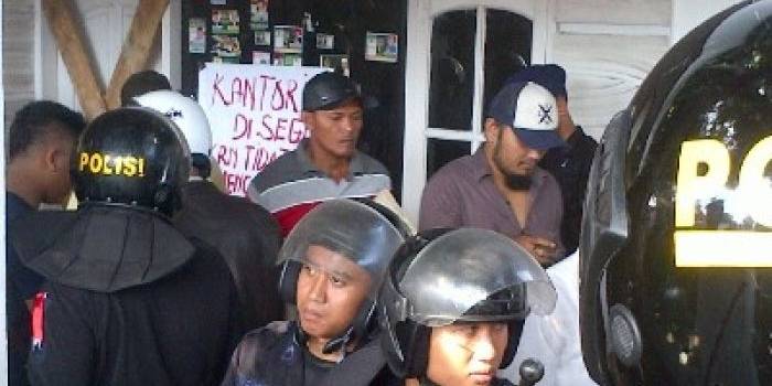 Polisi menjaga kantor PBB Pamekasan yang disegel massa pendukung Tamyiz, caleg DPRD setempat dari PBB. foto: rizal/Bangsa Online