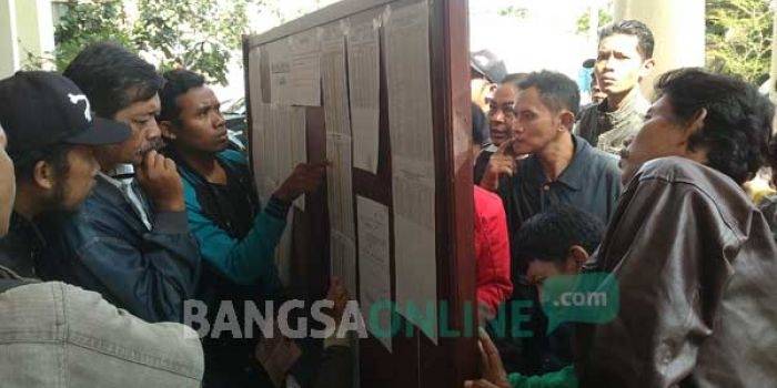 BERDESAKAN: Para pelanggar tilang saat mencocokkan nomer register tilang dengan nomor sidang. foto : nanang ichwan/ BANGSAONLINE