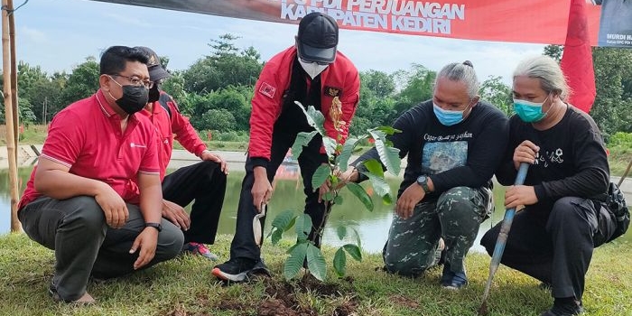 Ketua DPC PDIP Kabupaten Kediri Murdi Hantoro (tengah) didampingi Koordinator ARPL Kediri Ari Purnomo Adi, saat menanam pohon di area Embung Karanglo, Desa Tarokan. Foto: MUJI HARJITA/ BANGSAONLINE