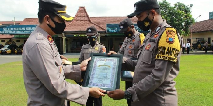 Wakapolres Mojokerto Kota Kompol Dr. Sarwo Waskito menyerahkan penghargaan kepada personel berprestasi saat apel pagi di Lapangan Apel Maha Patih Gajah Mada, Senin (18/10) pagi.