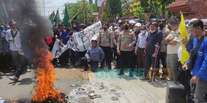 Aliansi Mahasiswa Mojokerto Raya berdemo di depan kantor Pemkot Mojokerto sambil bakar ban. Foto: YUDI EP/ BANGSAONLINE