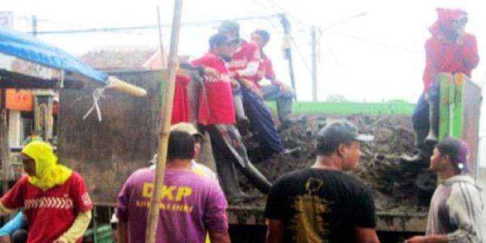 Petugas DKP saat membersihkan drainase untuk dilakukan normalisasi. foto: arif kurniawan/BANGSAONLINE