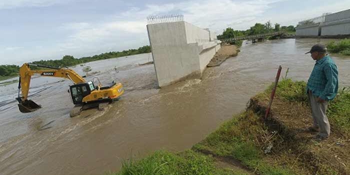 Tampak aliran air sungai yang jebol menggenangi area proyek jalan tol. 