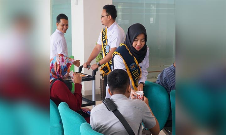Duta Layanan Kantor Imigrasi Kediri saat memberikan makanan ringan (cemilan) dan minuman kepada pemohon Paspor. (foto: ist)