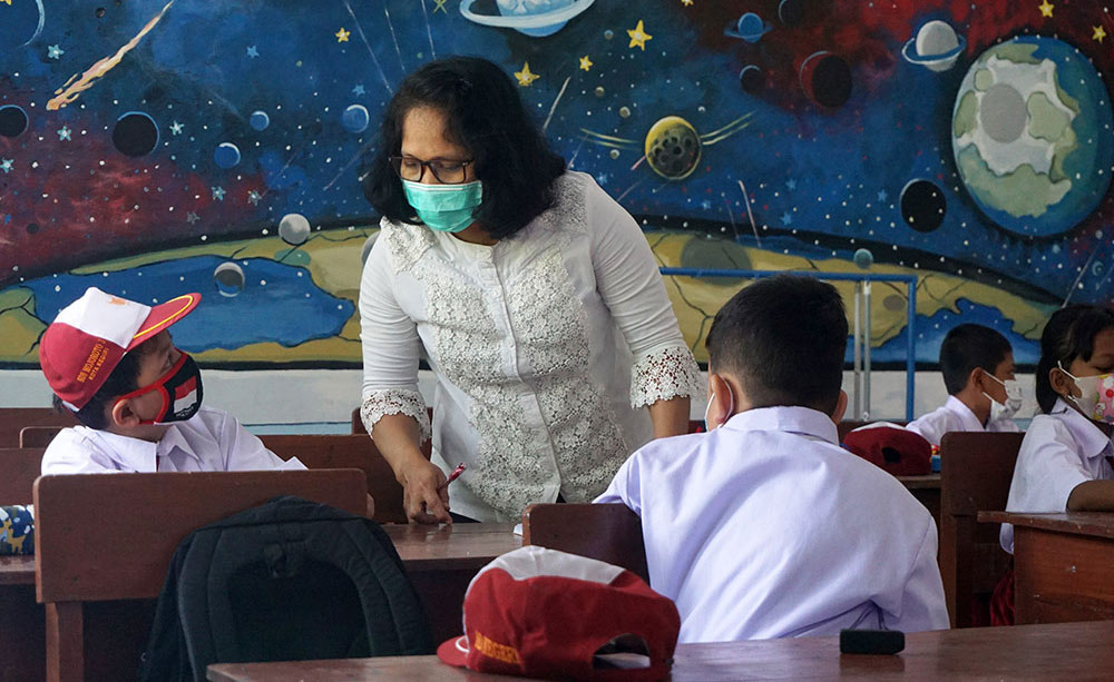 Seorang Ibu Guru saat berinteraksi dengan muridnya. Foto: Ist.