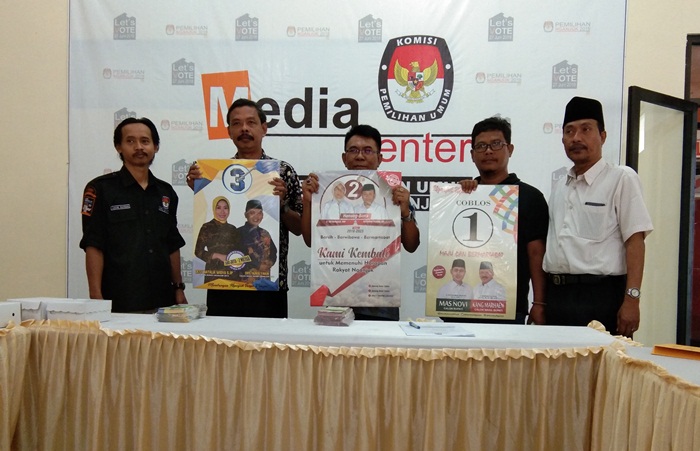 Ketua KPU Nganjuk (kanan) dan Ketua Panwaslu Nganjuk (kiri) mengapit perwakilan tiga paslon, usai penandatanganan berita acara penyerahan APK dan BK. foto: Bambang /BANGSAONLINE