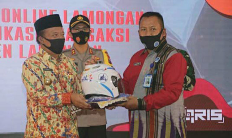 Bupati Fadeli menyerahkan fasilitas POL kepada Direktur Perumda Pasar Lamongan Suhartono. (foto: ist)