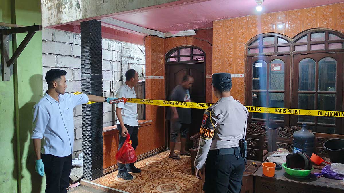 Petugas dari Polsek Kebomas saat melakukan olah TKP, dan memasang garis polisi di rumah korban. Foto: Ist
