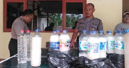 MIRAS: Anggota Polsek Kota Bojonegoro sedang menunjukan barang bukti puluhan liter miras hasil grebekan di beberapa warung sekitar kota. Foto: Eky Nurhadi/Bangsaonline.com