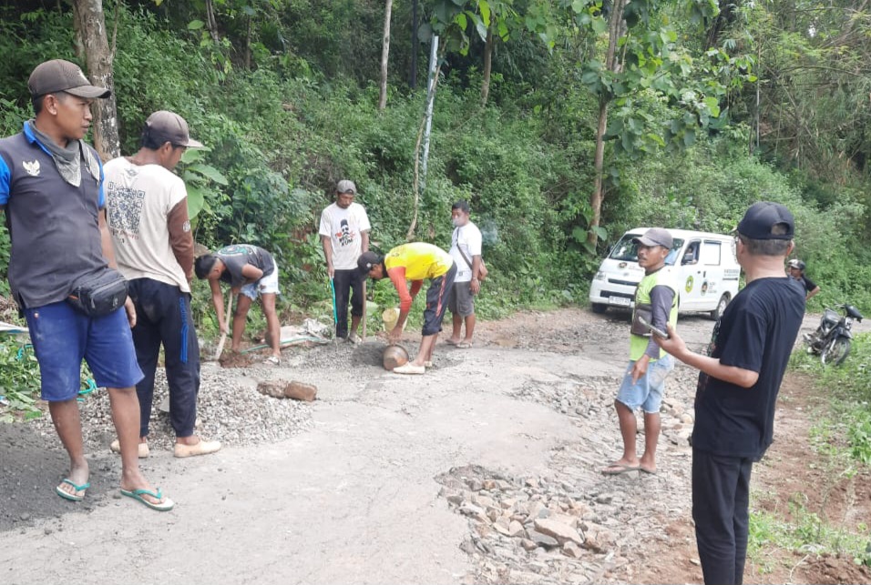 Warga saat bergotong royong melakukan perbaikan jalan