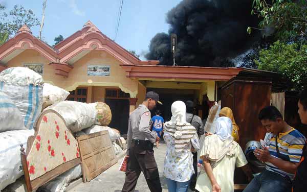 ?Tampak gudang rosokan milik Sumono saat terbakar ditonton warga sekitar. Foto: herman subagyo/BANGSAONLINE