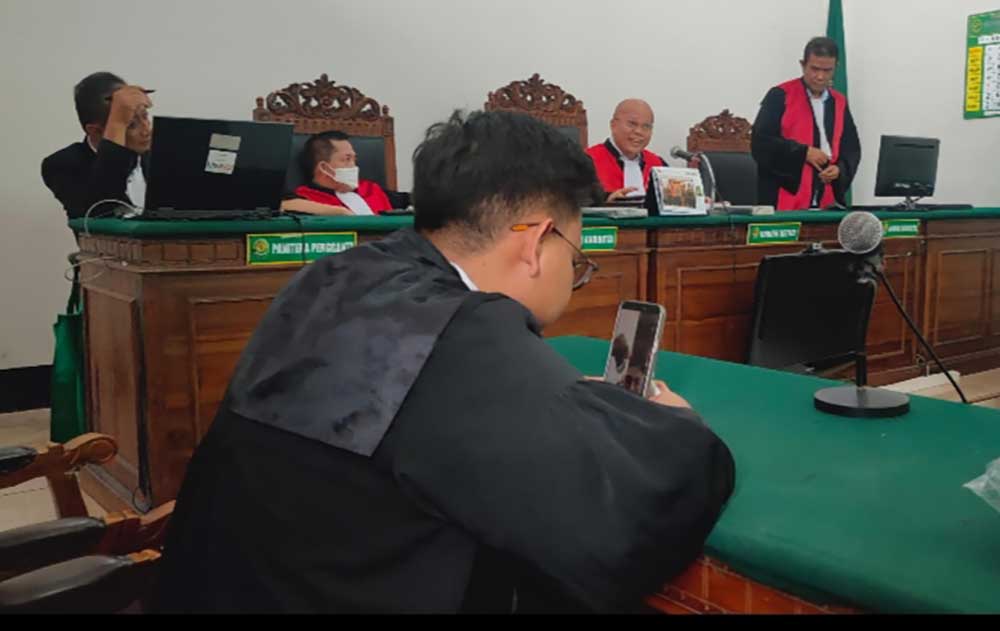 Kuasa hukum terdakwa mendengarkan dakwaan dari JPU. Sedangkan terdakwa sendiri ada di rutan mengikuti sidang secara online.
