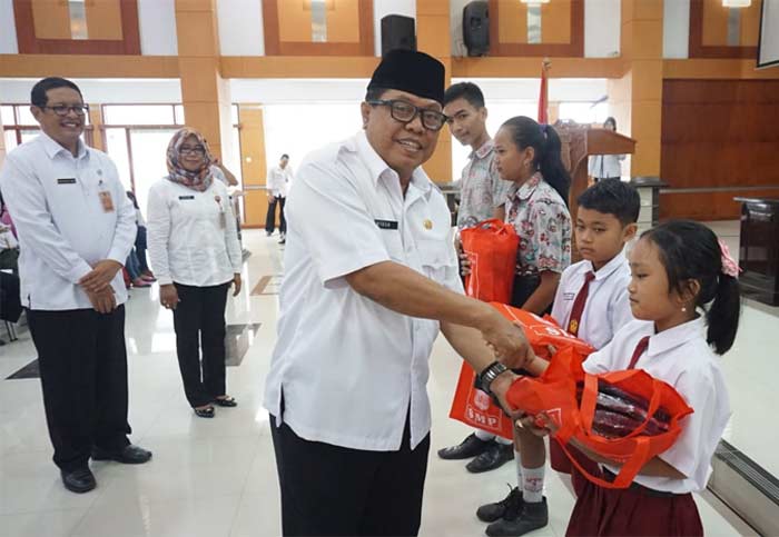 Wakil Wali Kota Blitar Santoso saat membagikan seragam kepada sejumlah siswa siswi SD dan SMP. foto: AKINA/ BANGSAONLINE