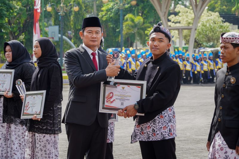 Yuhronur Efendi, Bupati Lamongan menyerahkan apresiasi kepada Kurniawan saat upacara Hari Sumpah Pemuda ke-97