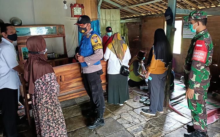 Petugas mengecek warga desa yang diduga mengalami keracunan usai menyantap nasi kotak yang didapat dari acara hajatan.
