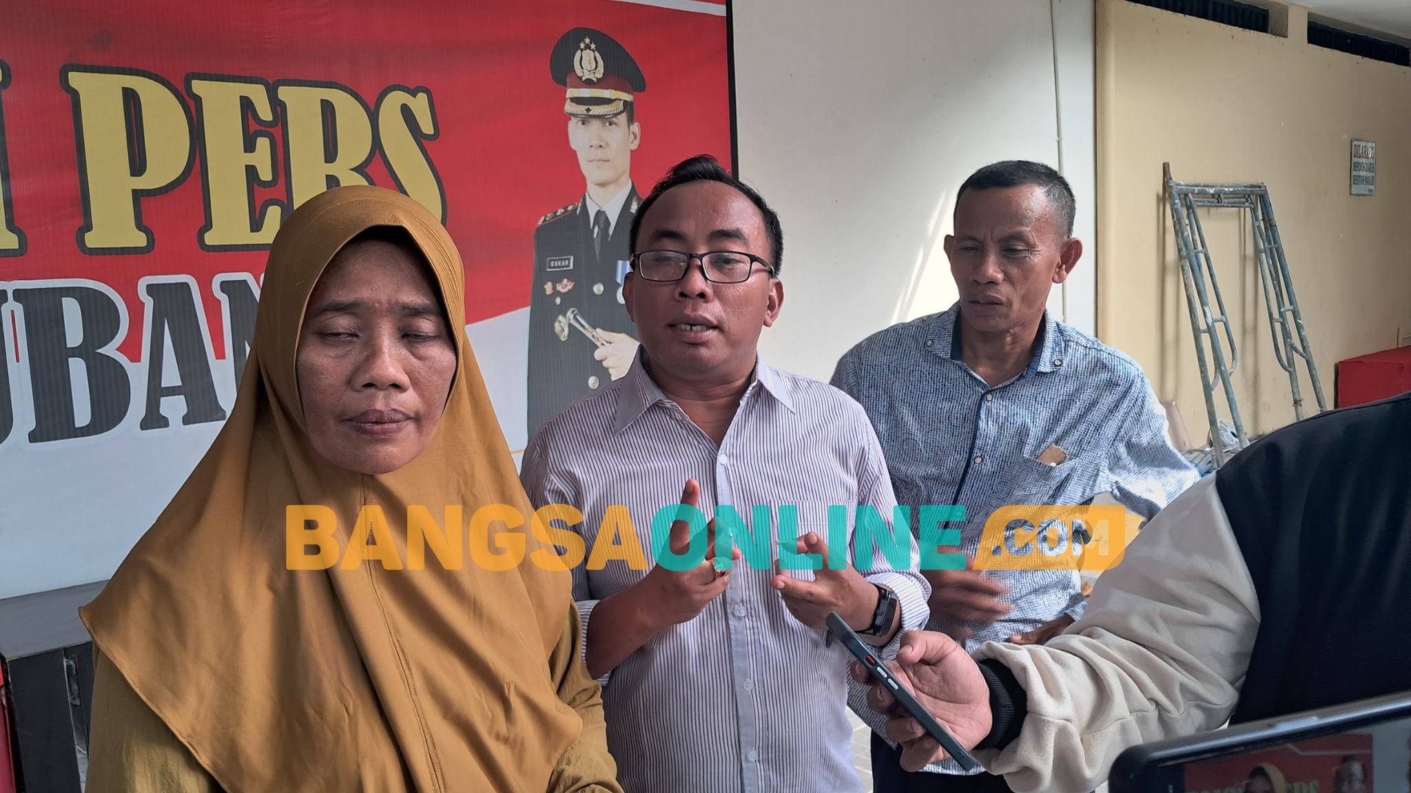 Kuasa Hukum pelapor, Nur Aziz (tengah), menyampaikan keterangan kepada awak media di Mapolres Tuban. Foto: ACHMAD CHOIRUDIN/ BANGSAONLINE