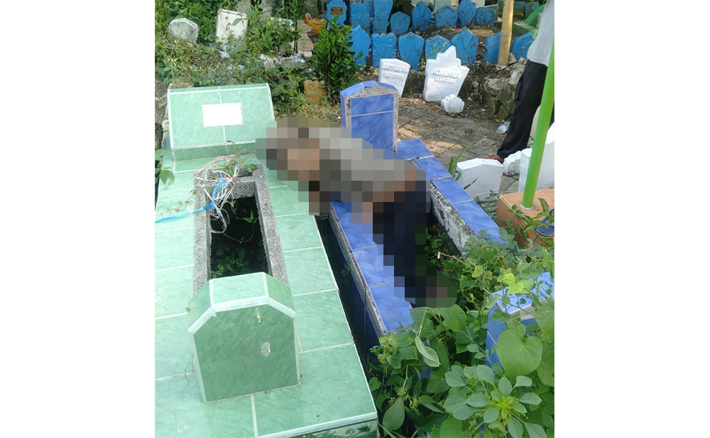 Kondisi Muhammad Subandrio (61), warga Jalan Sindujoyo, Kelurahan Kroman, Kecamatan Gresik, saat ditemukan meninggal di atas kuburan. Foto: Ist.