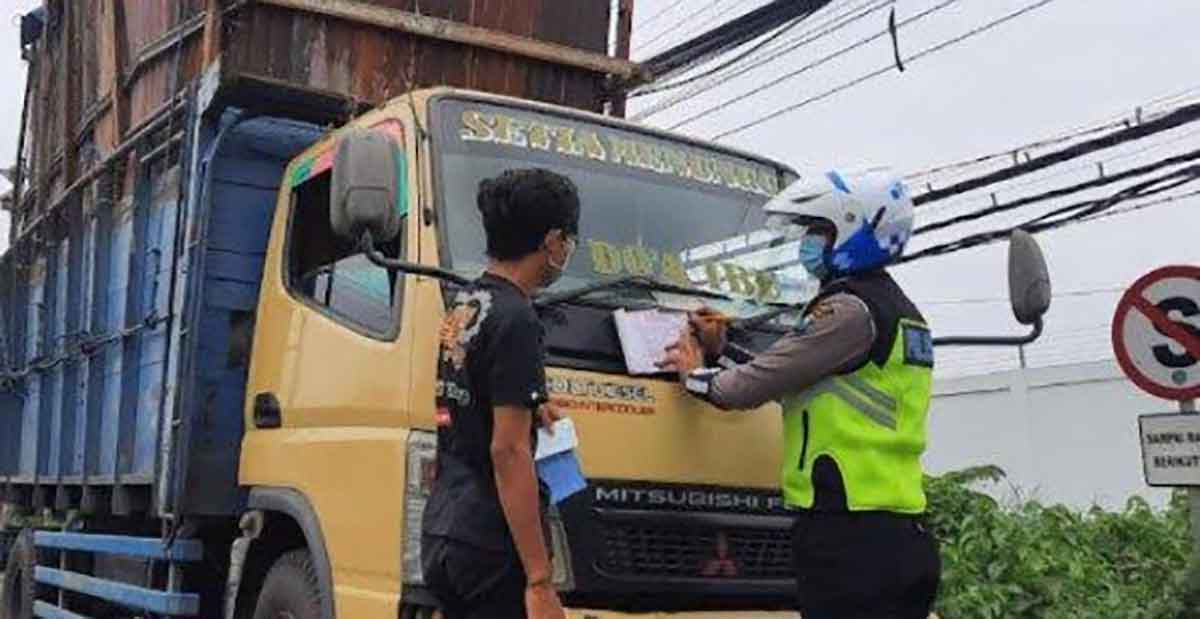 Petugas saat menilang kendaraan yang melanggar aturan.