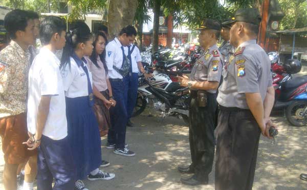 PENGARAHAN - Polisi memberikan pengarahan pada sejumlah pelajar yang terjaring razia karena nongkrong di stadion Anjuk Ladang, Nganjuk. foto: soewandito/BANGSAONLINE