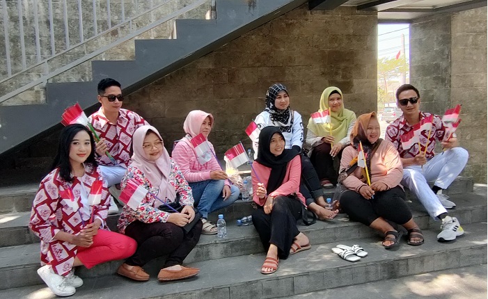 
Alivia Chairani (kiri), Dendy Septya Nugraha dan Indro Tri Cahyono dengan mengenakan batik khas Kabupaten Kediri motif jagad merah putih, usai membagikan bendera merah putih kepada pengunjung Kediri Memorial Park. (Foto: Muji Harjita/BANGSAONLINE.com).
