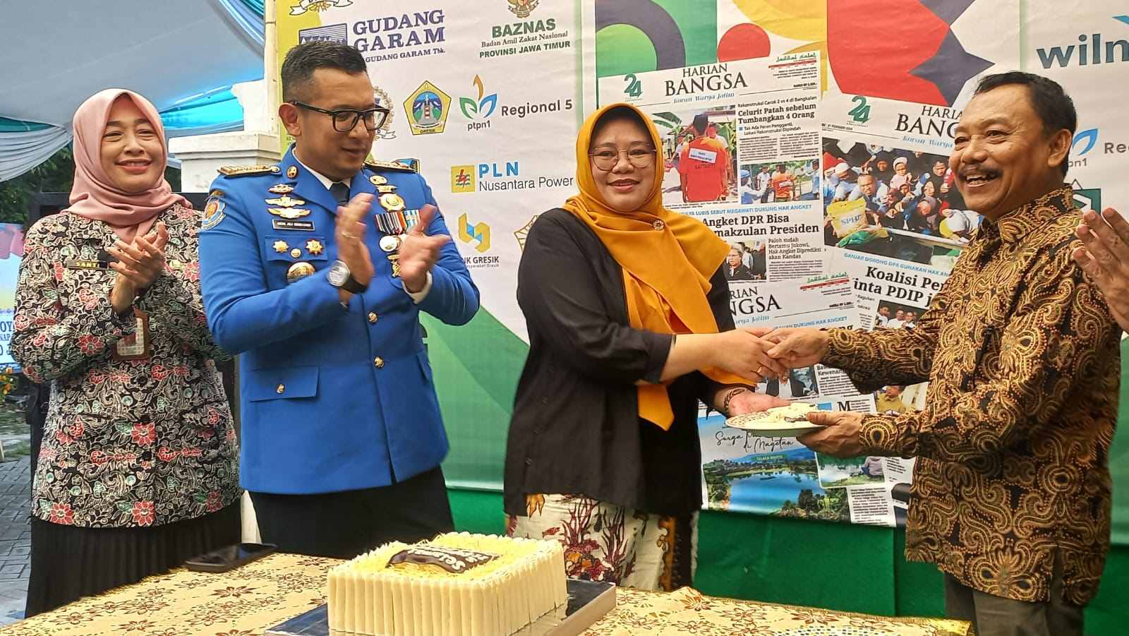 Kepala Dnas Kominfo Jatim Sherlita Ratna Dewi Agustin memberikan potongan kue tart kepada CEO HARIAN BANGSA M. Mas