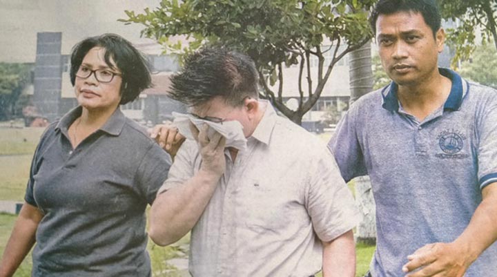 Pendeta Hanny Layantara (tengah) saat dibawa oleh dua penyidik Polda Jatim di Mapolda Jatim. foto: Jawa pos