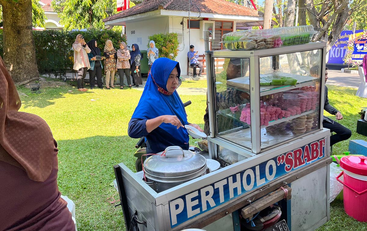 Suryanti saat menyajikan jajanan tradisional pertulo dan surabi di HUT Kota Kediri. Foto: Ist.