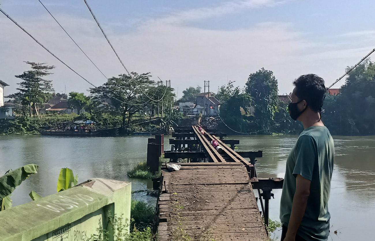 Hamam, salah seorang warga saat memandangi sisa Jembatan Mrican yang dibongkar. foto: Muji Harjita/ BANGSAONLINE.com