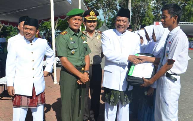 Bupati Sambari HR, didampingi pejabat Forkompimda memberi penghargaan siswa berprestasi saat upacara Hardiknas. foto: syuhud/ BANGSAONLINE