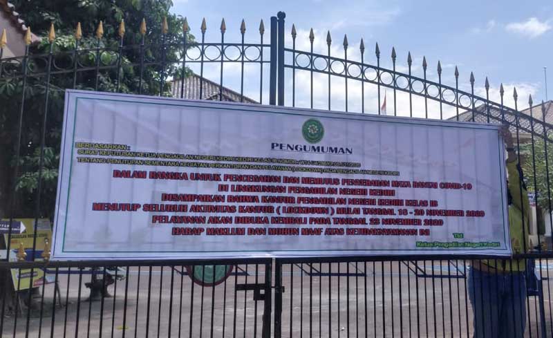 Papan pengumuman lockdown yang terpasang di pintu masuk Kantor PN Kota Kediri. 