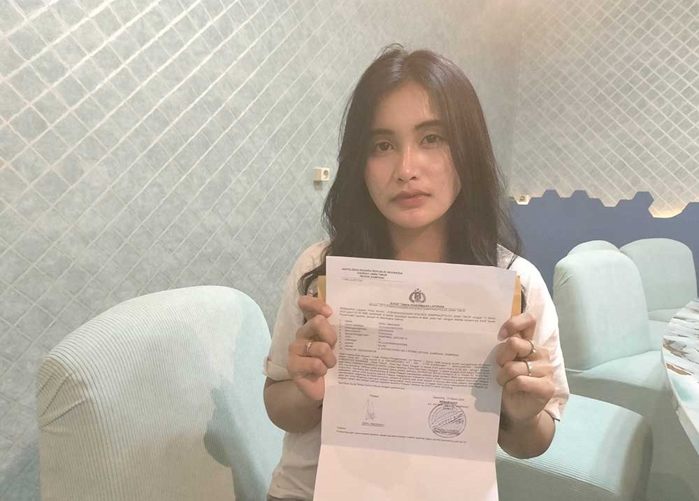 Serli, Penyanyi dangdut KDI saat menunjukkan surat laporan polisi. Foto: Mutammim/BANGSAONLINE.com