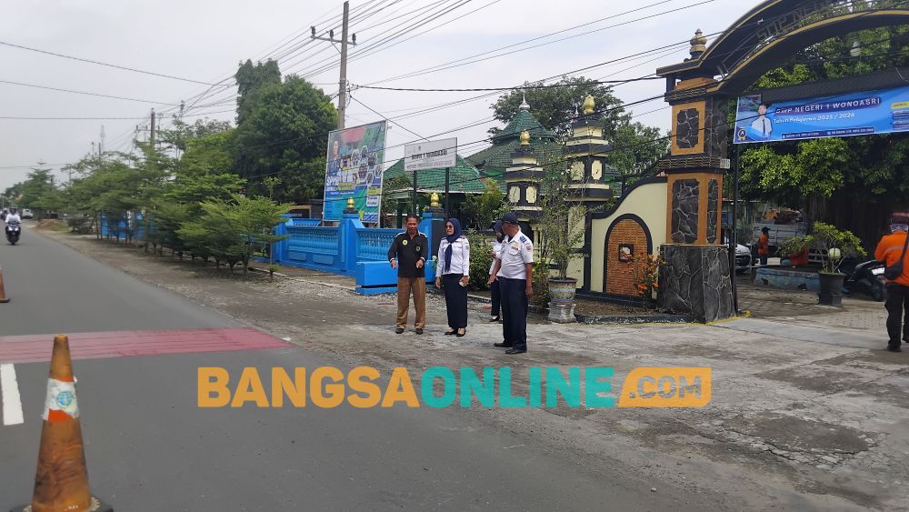 Kabid Sarpras Dishub didamping Kepala SMPN 1 Wonoasri melihat pengerjaan ZoSS. Foto: Hendro Suhartono/BANGSAONLINE