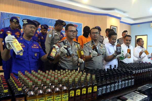 Kabid Humas Polda Jatim Frans Barung Bangera SIK, didampingi Wadir Pol Air AKBP Sulistyono  saat membeber kasus minuman keras ilegal. foto: anastasia/BANGSAONLINE