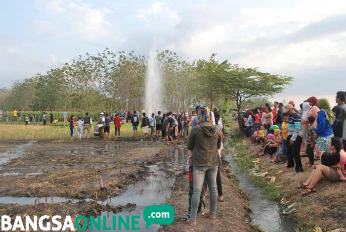 Warga yang melihat semburan air di Desa Sidolaju Kecamatan Widodaren semakin berjubel. foto: ZAINAL A/ BANGSAONLINE