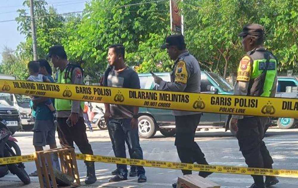 Personel Polsek Kalitidu memasing garis polisi di lokasi penemuan benda mirip mortir di depan Pasar Pungpungan, Kamis (6/6/2024) pagi.